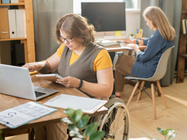 young-busy-disable-office-manager-casualwear-sitting-wheelchair-front-laptop-networking-while-her-colleague-working (1)